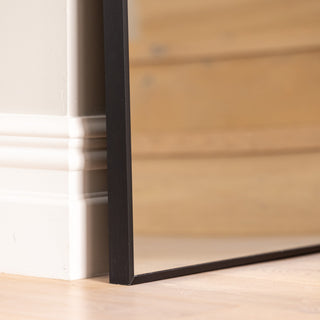 Close-up of the Zenith X full-length mirror’s bottom corner, showcasing the clean 30 mm aluminium alloy frame and ultra-clear 3 mm glass. The precise edge alignment and smooth black finish highlight the mirror’s refined craftsmanship and modern minimalist appeal.