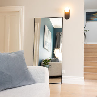 Zenith X full-length mirror (180 x 80 cm) featuring a sleek 30 mm black aluminium alloy frame and ultra-clear 3 mm glass, styled in a bright modern living space. The mirror reflects a cosy interior with blue accent walls, soft furnishings, and natural light, adding depth and elegance to the room.