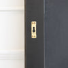 Close-up of a brass keyhole wall hanging bracket on the matte black rear of the Cascade X irregular frameless mirror, C&F Creation