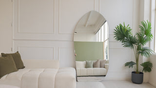 Cascade X irregular frameless full-length mirror leaning in an NZ living room with a cream couch and palm plant, 200 by 100cm, C&F Creation